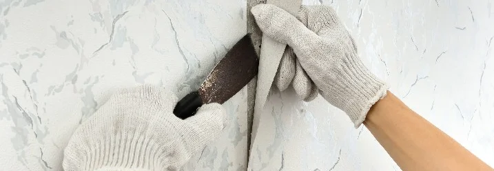 Hände entfernen Tapete mit Spachtel